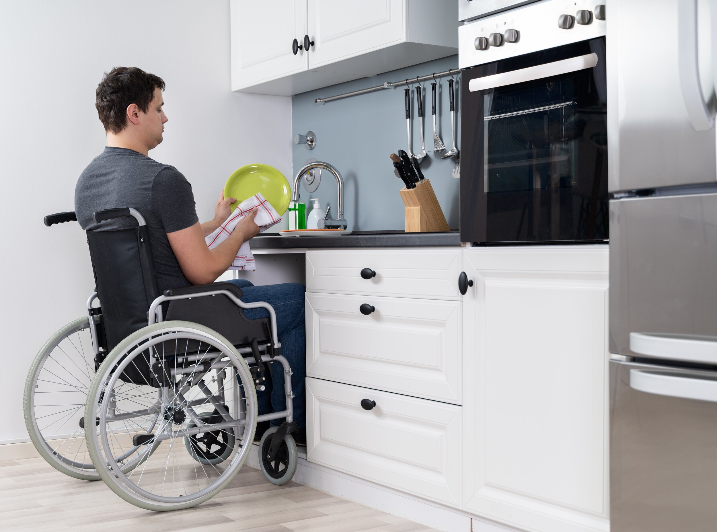 Handicapped,Man,Sitting,On,Wheelchair,Washing,And,Cleaning,Dishes,In